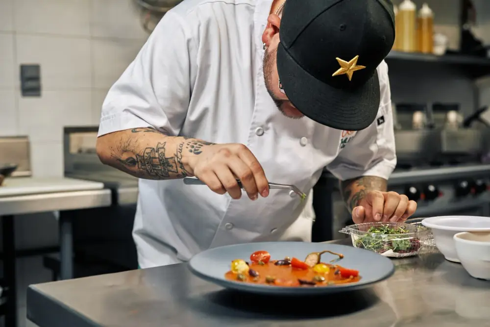 Chef dressant une assiette gastronomique dans la cuisine de son restaurant