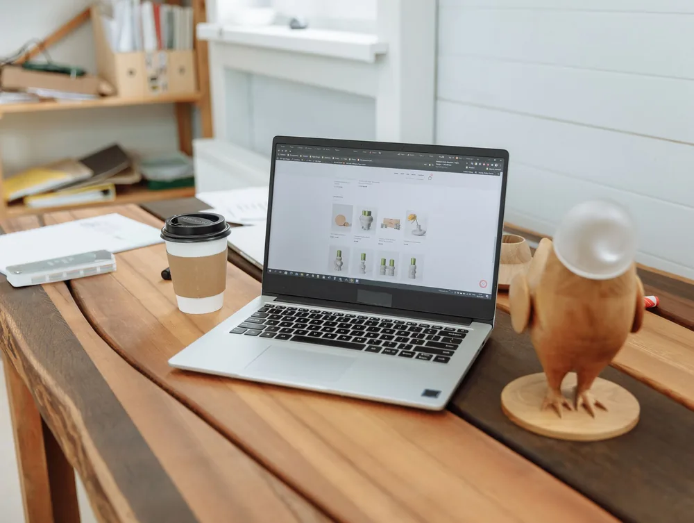 Ordinateur portable affichant un site web sur un bureau en bois clair