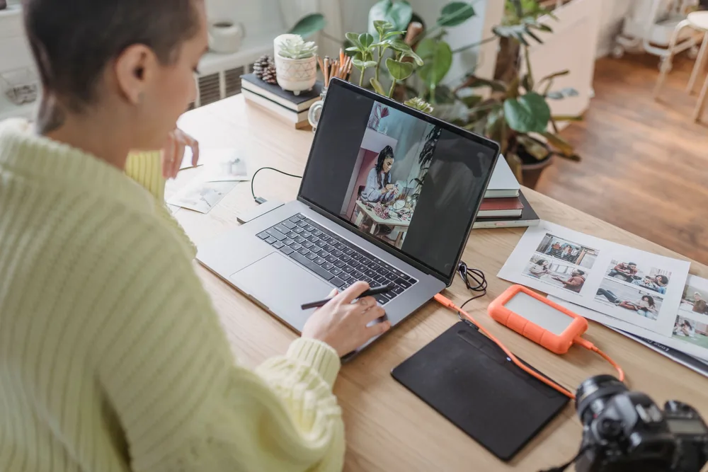 Photographe indépendante vérifiant ses clichés près de sa tablette graphique