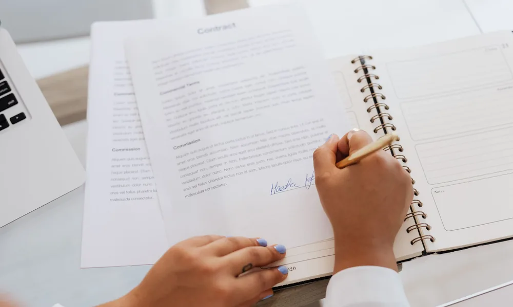 Cliente signant un document au comptoir d'un cabinet