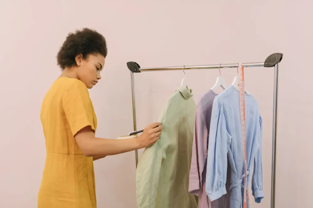 Commerçante vérifiant les vêtements d'un portant dans sa boutique