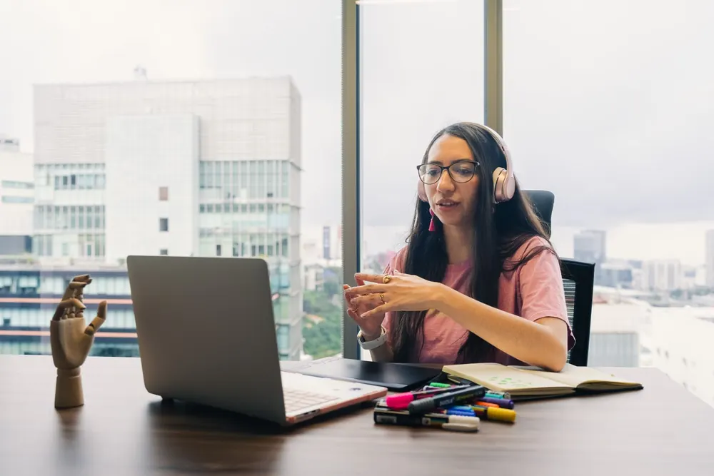 Consultante indépendante en visioconférence avec un casque, devant son ordinateur