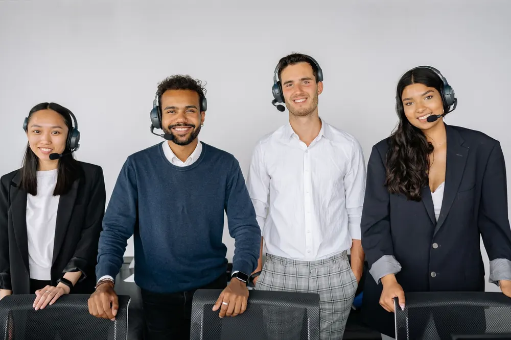 Équipe du support client souriante, casques micro sur la tête