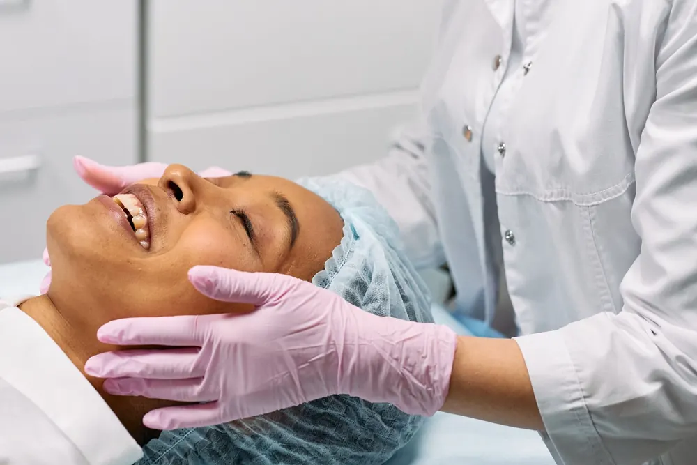 Esthéticienne réalisant un soin du visage à une cliente détendue