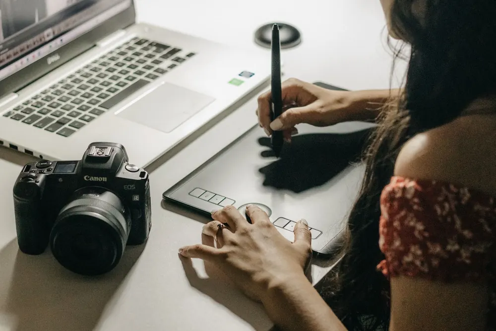 Graphiste indépendante dessinant sur sa tablette graphique, appareil photo à côté