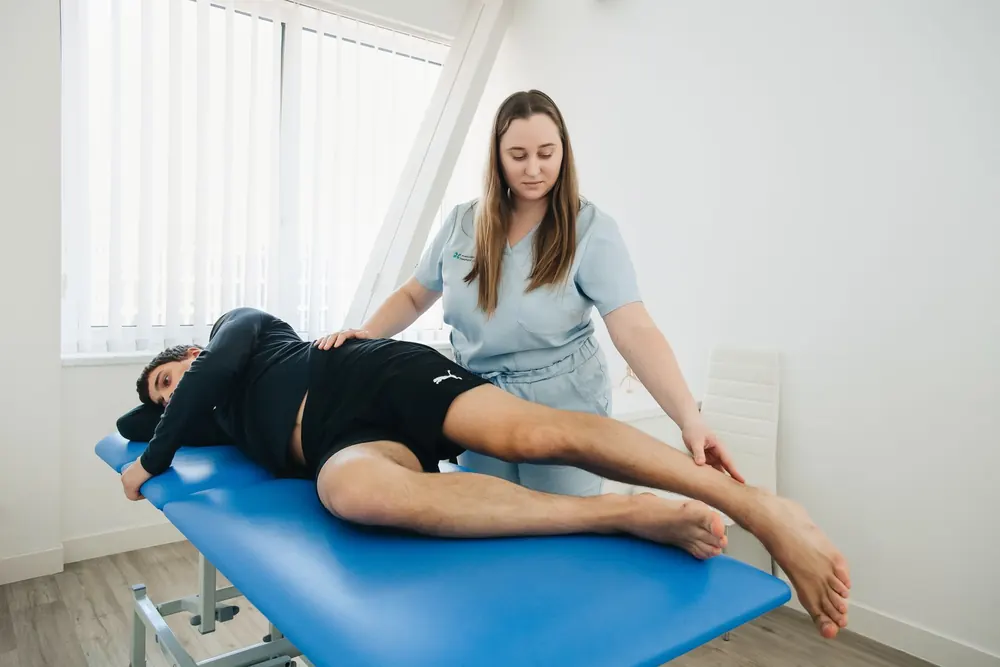 Kinésithérapeute accompagnant un patient lors d'une séance de rééducation